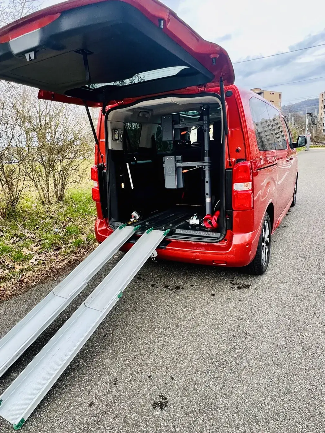 Rotes Rollstuhlfahrzeug von Aaaba Taxi mit Heckrampe
