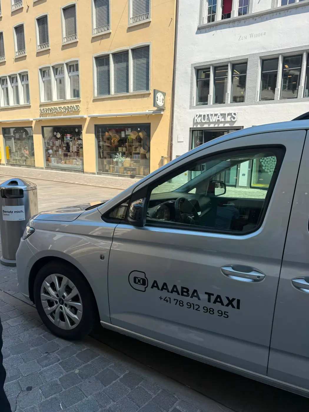 Silbernes Rollstuhlfahrzeug von Aaaba Taxi von der Seite